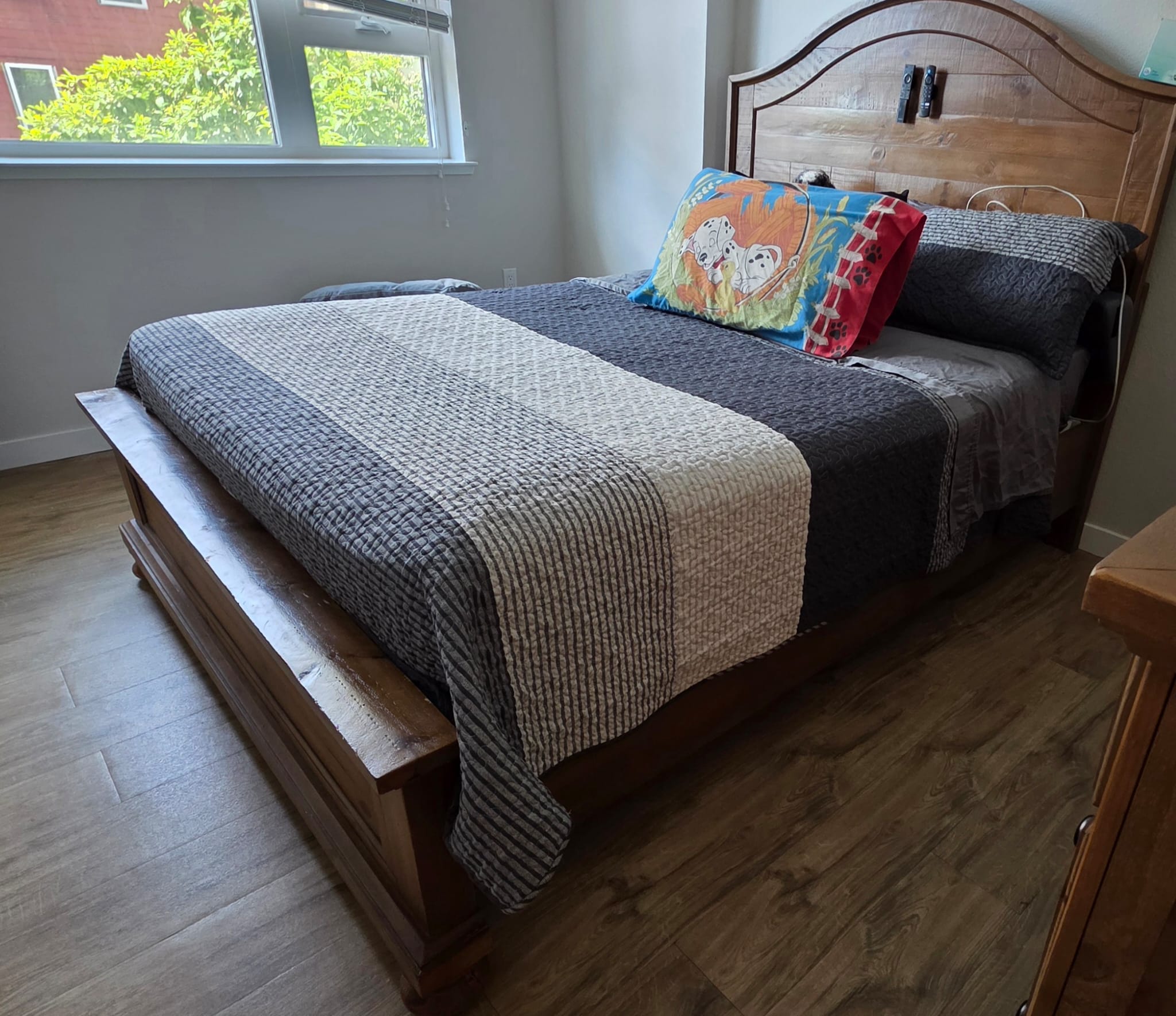 Cama de madera con la ropa de cama acomodada después del servicio de Goncan